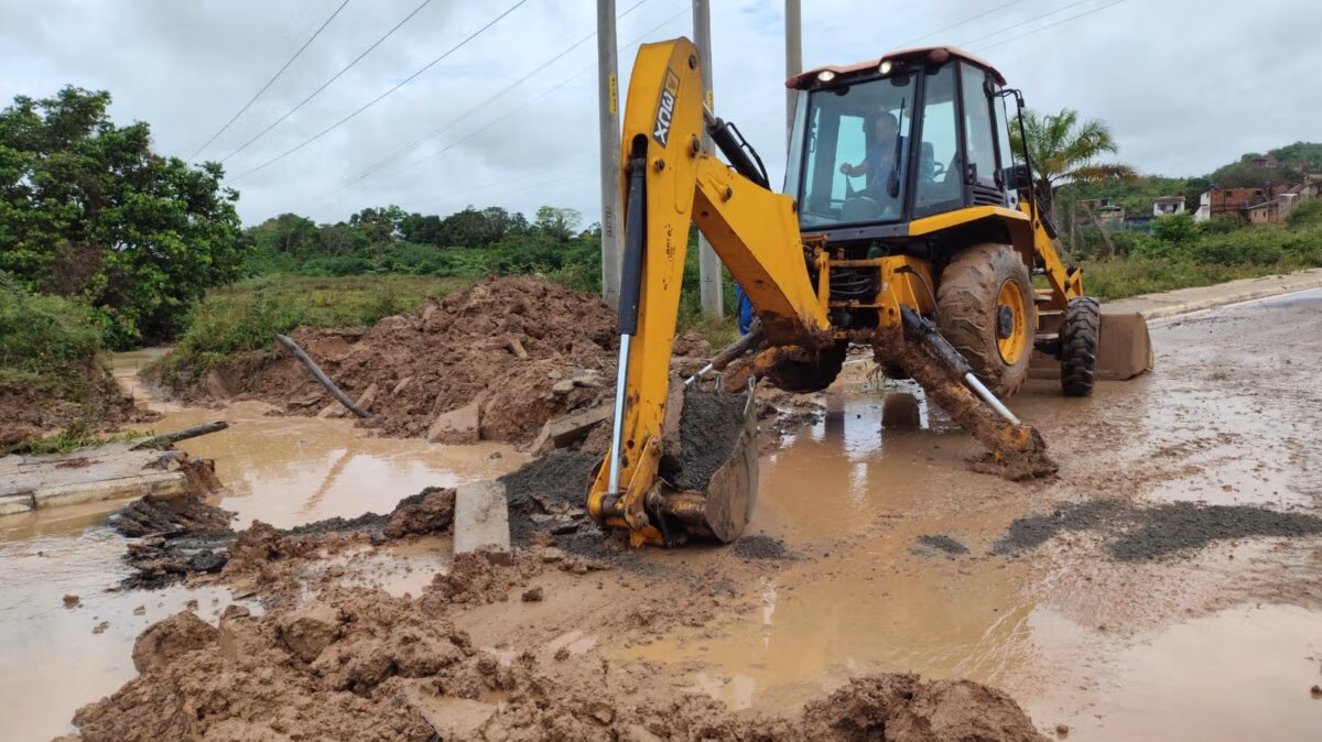 Prefeitura de Santo Amaro rompe asfalto para facilitar escoamento do rio Sergimirim 2 retroescavadeira rompendo asfalto para passagem do rio sergimirim