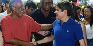 ACM Neto andando na rua e apertando a mão de um homem