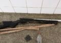 Uma espingarda de caça de madeira e metal deitada sobre uma mesa