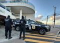 Carro da Polícia Civil com dois policiais parados em frente a uma residência
