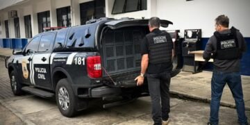 Policiais abrindo o carro da Polícia Civil da Bahia