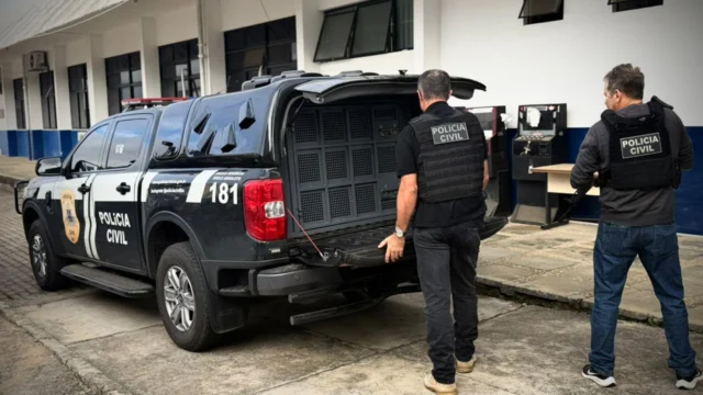 Policiais abrindo o carro da Polícia Civil da Bahia