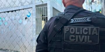 policial civil na rua, de costas para a foto, durante operação em Salvador