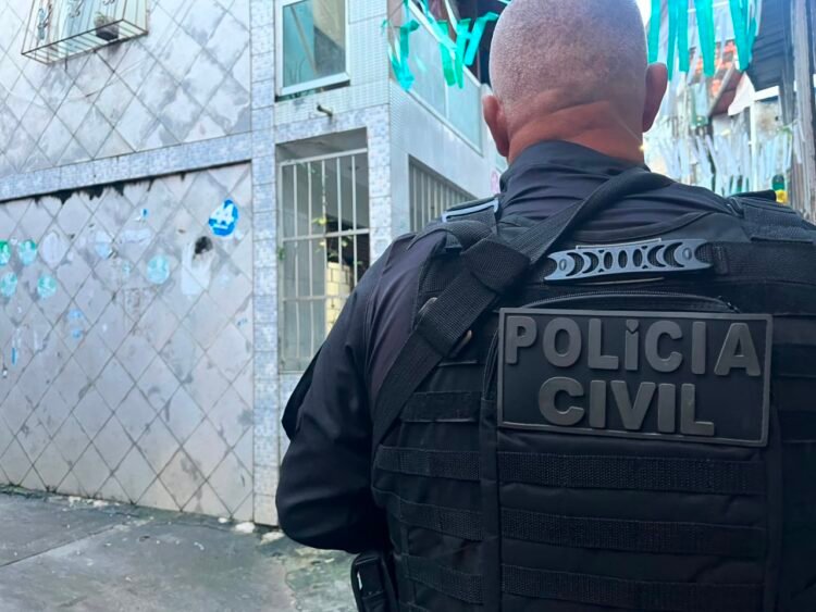 policial civil na rua, de costas para a foto, durante operação em Salvador