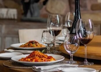clube do vinho - imagem de mesa posta com garrafa de vinho, taça e jantar servido