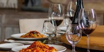 clube do vinho - imagem de mesa posta com garrafa de vinho, taça e jantar servido