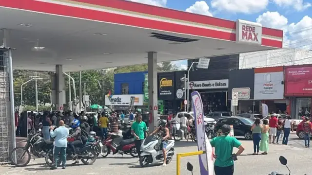 rua do centro de feira de santana com aglomeração de pessoas próximo a posto de combustivel