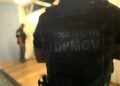 Imagem de um policial, de costas, mostrando o colete escrito: Polícia Civil - DPMCV