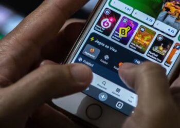 foto mostra uma pessoa segurando celular mostrando o app de uma bet aberto no aparelho
