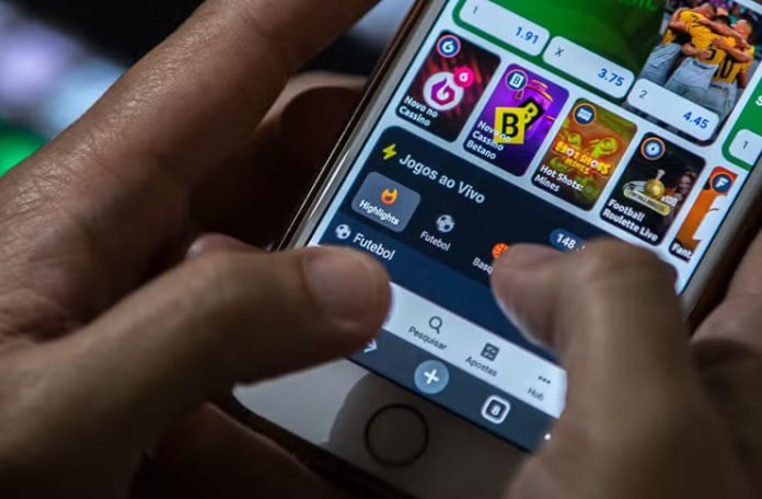 Estudo alerta para impacto das 'bets' na vida de mulheres e mães que buscam renda extra para pagar contas 1 foto mostra uma pessoa segurando celular mostrando o app de uma bet aberto no aparelho