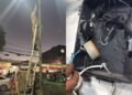foto de policial militar removendo câmera clandestina de poste em rua do bairro de Valéria em Salvador