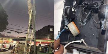 foto de policial militar removendo câmera clandestina de poste em rua do bairro de Valéria em Salvador