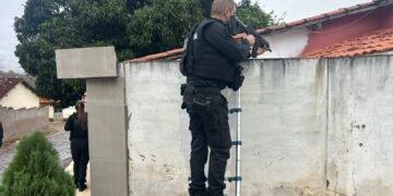 policial em muro de residencia