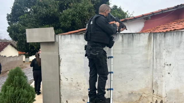 policial em muro de residencia