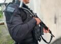 policial segurando arma enquanto trabalha
