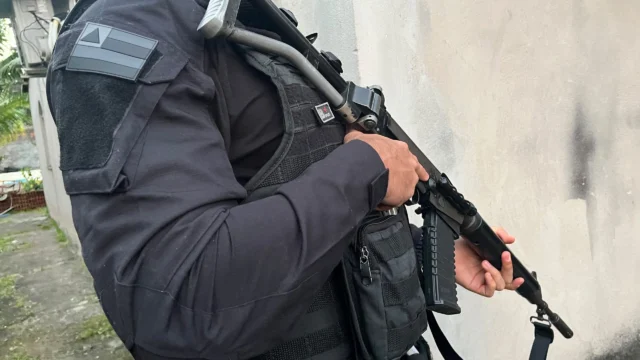 policial segurando arma enquanto trabalha