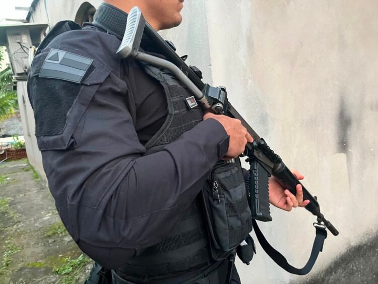 policial segurando arma enquanto trabalha
