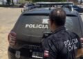 policial civil no fundo da viatura olhando para a lateral da imagem