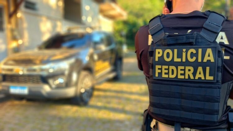 policial federal próximo a viatura da PF