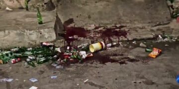 rua cheia de garrafas de cervejas no chão com manchas de sangue após tiroteio em festa paredão em Santo Amaro