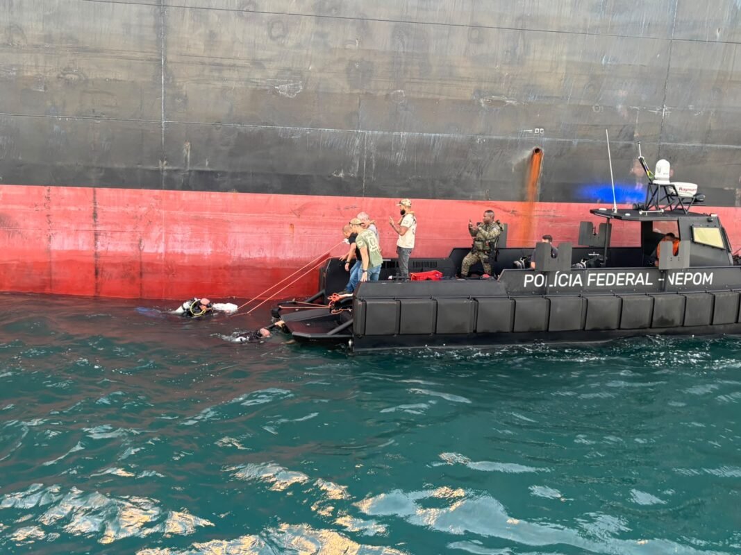 barco da Polícia Federal com policiais interceptando navio de cargas
