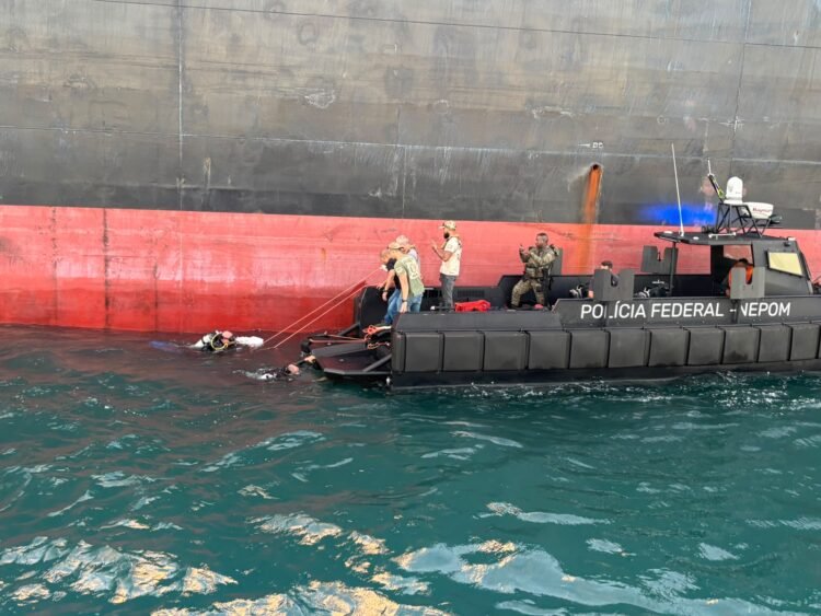 barco da Polícia Federal com policiais interceptando navio de cargas